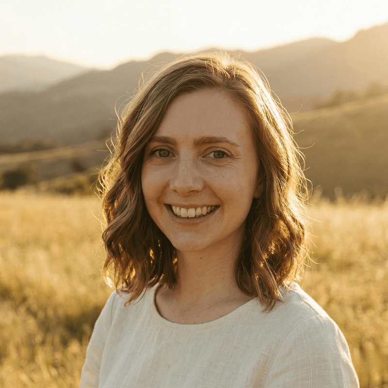 Tionna Honaker standing in a Montana field at golden hour